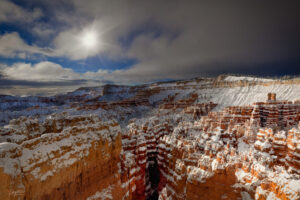 A two foot snowfall in Bryce Canyon begins to clear with the sun managing to peek through