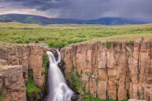 A turbulent falls within Clear Creek State Park, in Creede, Colorado is framed by a rain storm in the background.