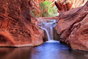 A serene summer day at the waterfall within Red Cliffs State Park.