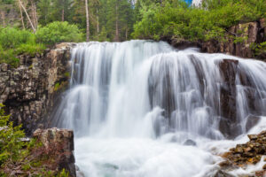 High running stream flow and resulting waterfall coming down from Sneffle's Peak in Ouray, Colorado